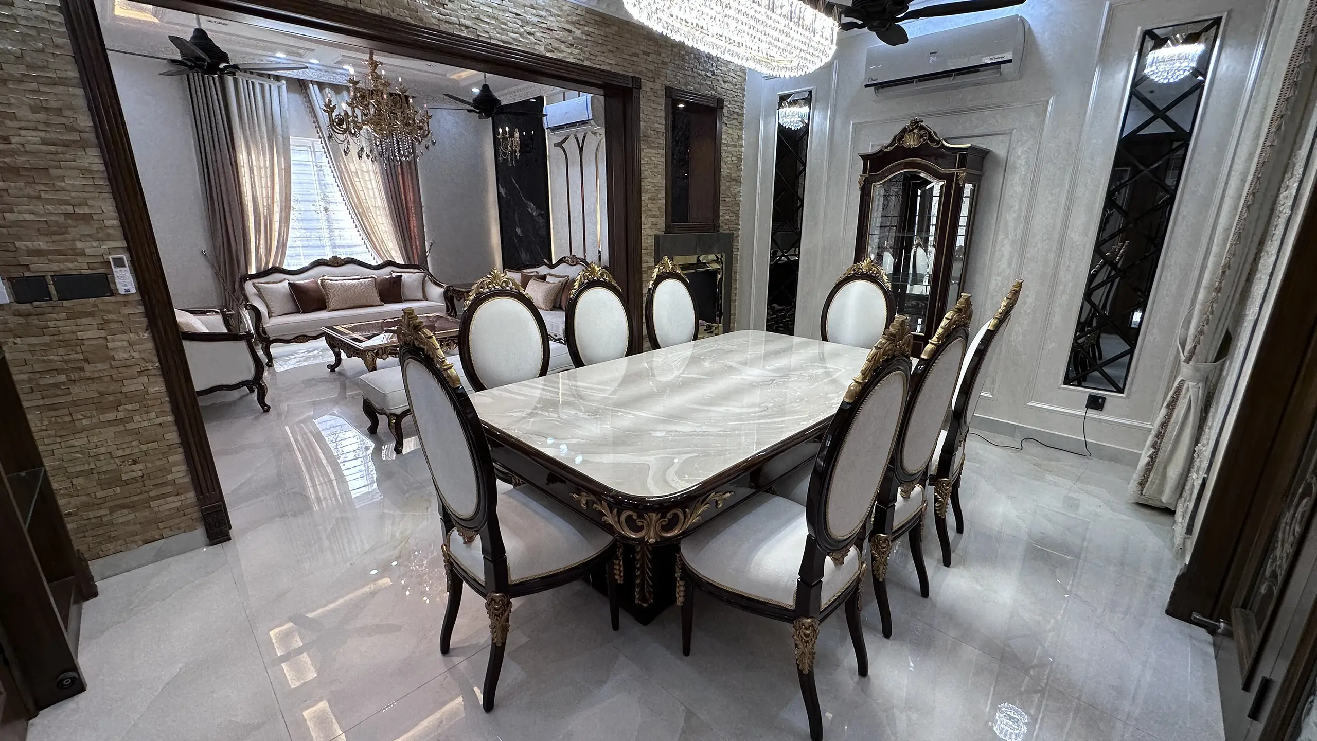 Elegant dining room with a marble-top table and a view of the adjacent classic drawing room.