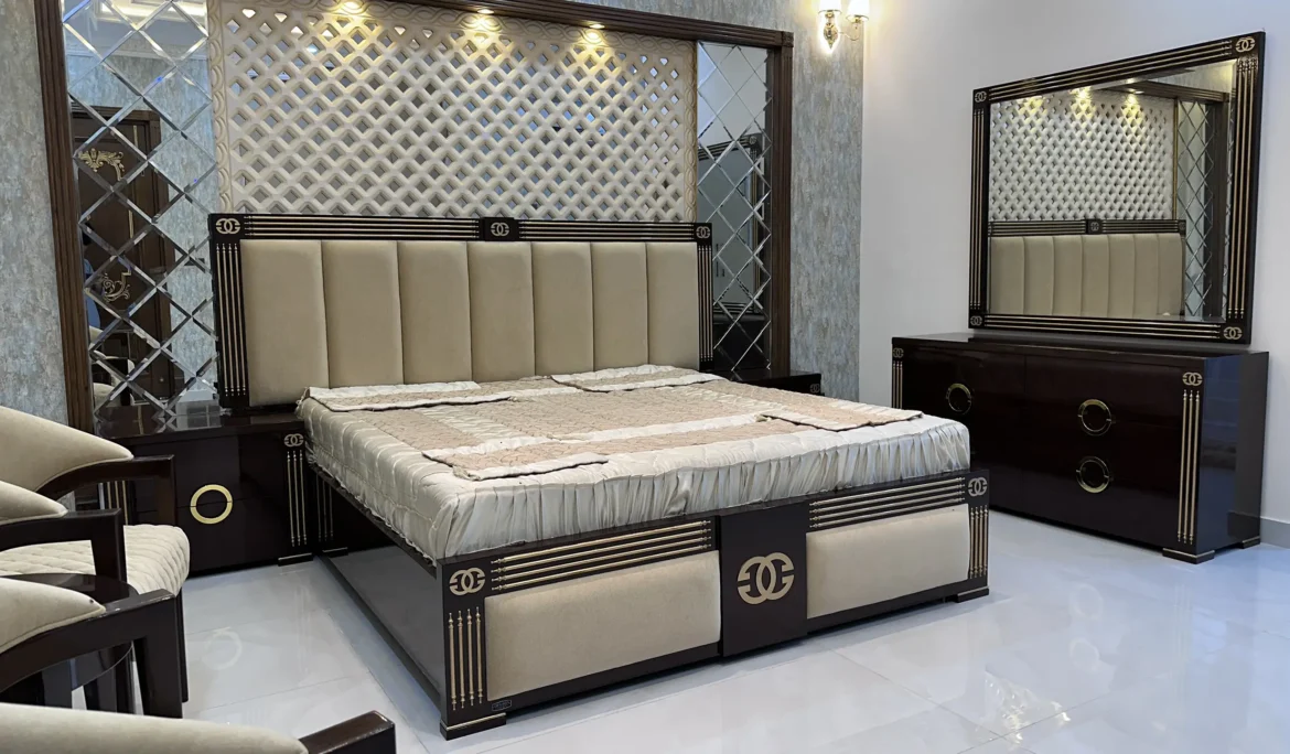 Modern bedroom showcasing a large upholstered bed, dark wood furniture, and mirrored wall accents.
