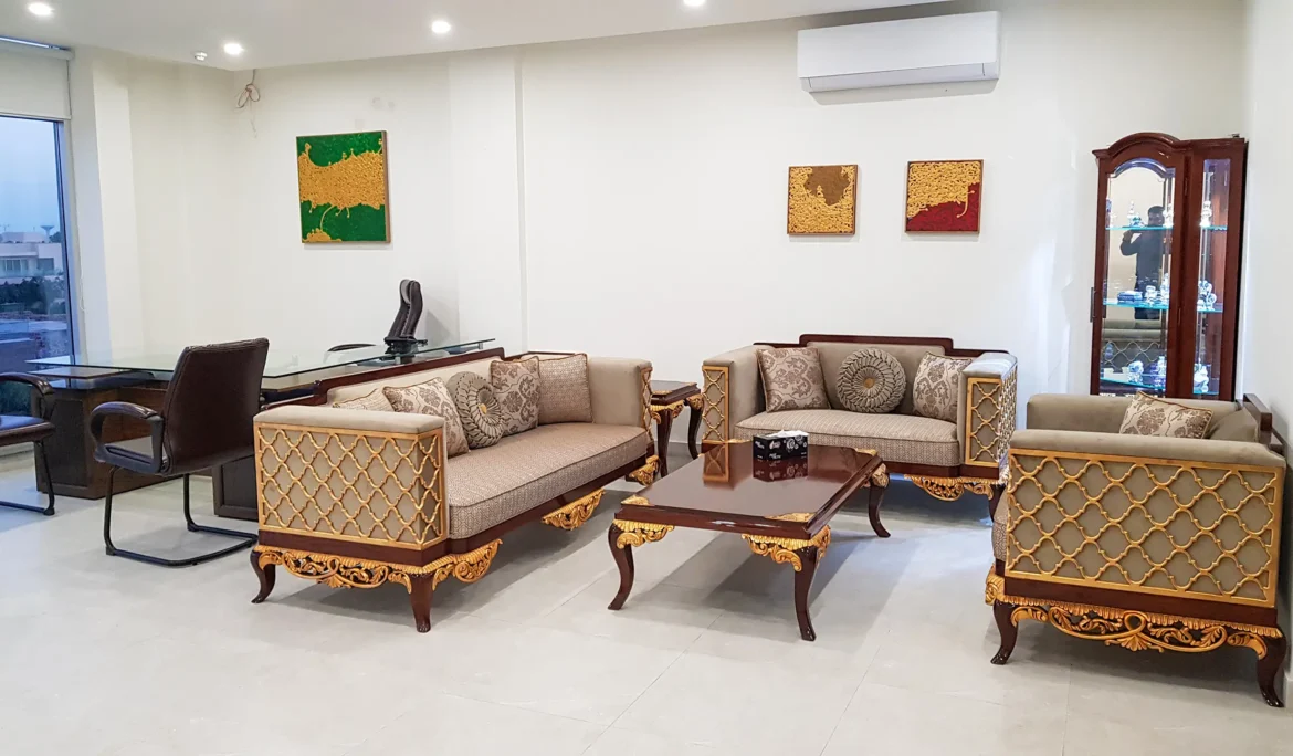 Classic carved wooden sofa set and executive desk in a formal office space.