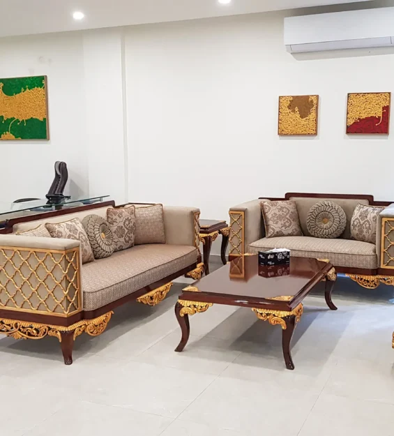 Classic carved wooden sofa set and executive desk in a formal office space.
