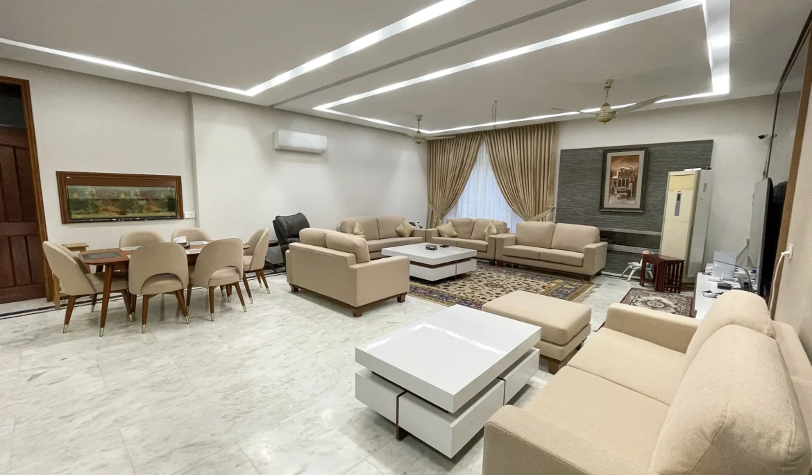 Spacious open-plan living and dining area with contemporary beige sofas and white coffee tables.