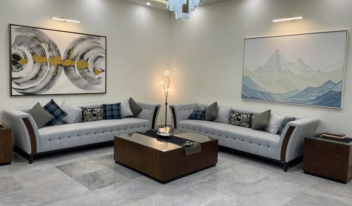 Spacious living room with two light grey sofas, a dark wood coffee table, and large abstract wall art.