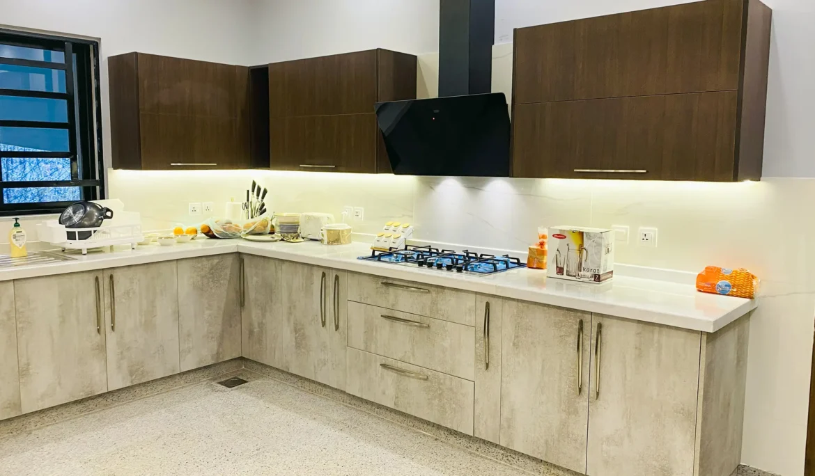 Two-tone modern kitchen with light wood-texture lower cabinets and dark upper cabinets.