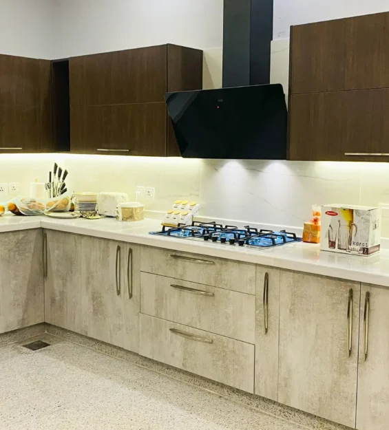 Two-tone modern kitchen with light wood-texture lower cabinets and dark upper cabinets.