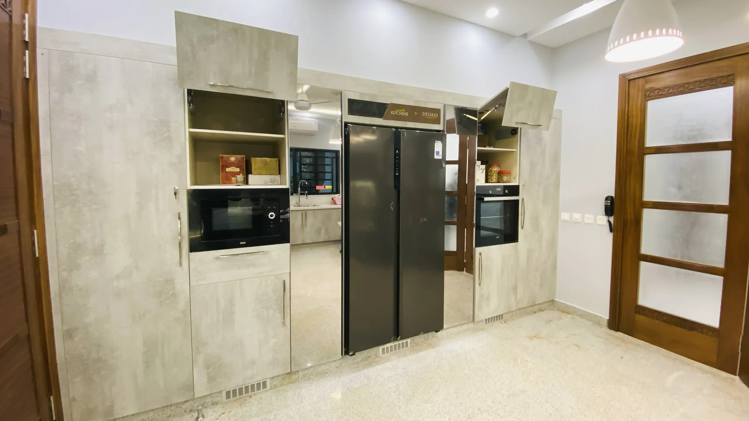 Floor-to-ceiling kitchen cabinets with an integrated refrigerator and built-in microwave and oven.