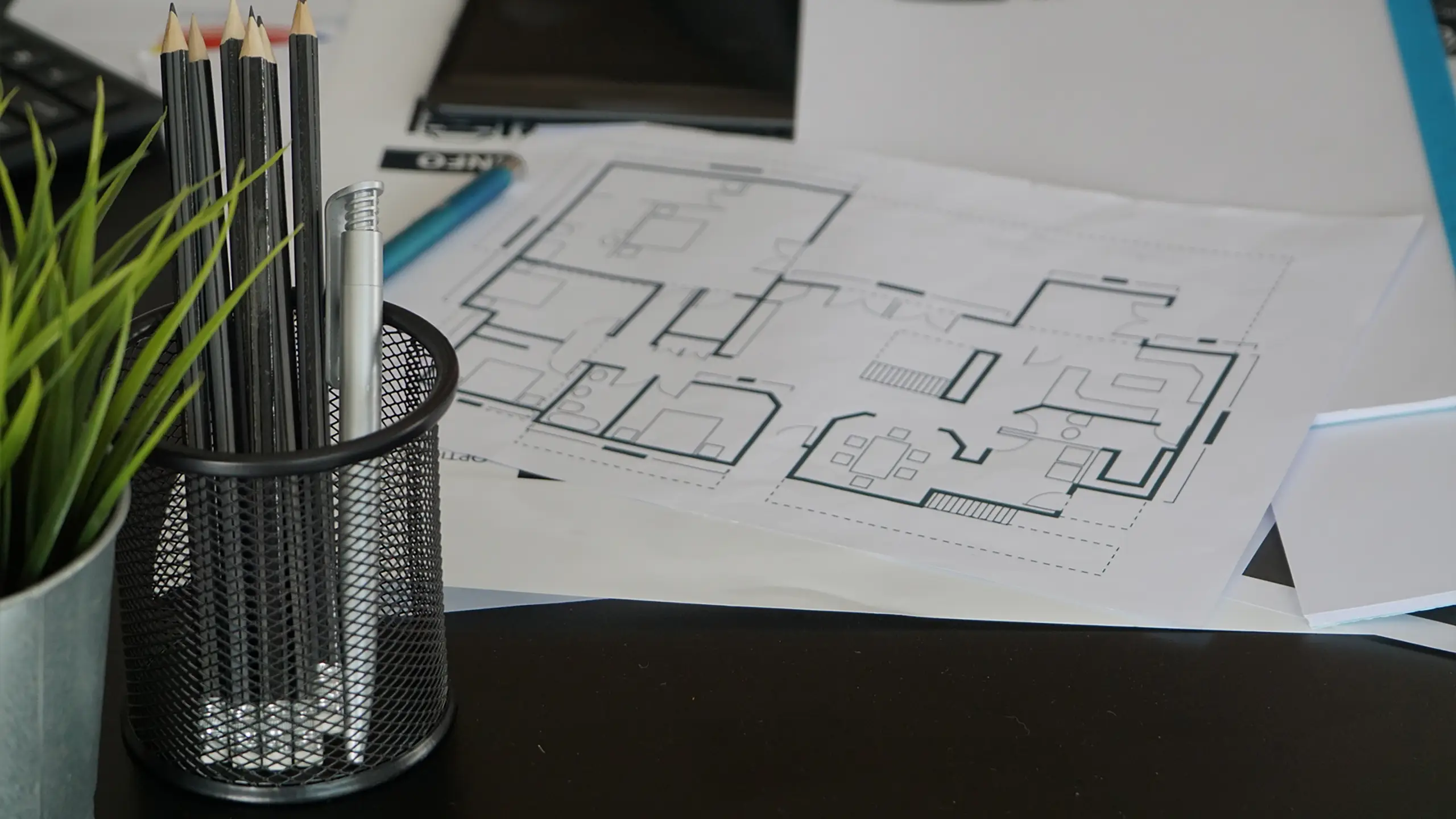 An architectural floor plan on a designer's desk, representing professional interior space planning.