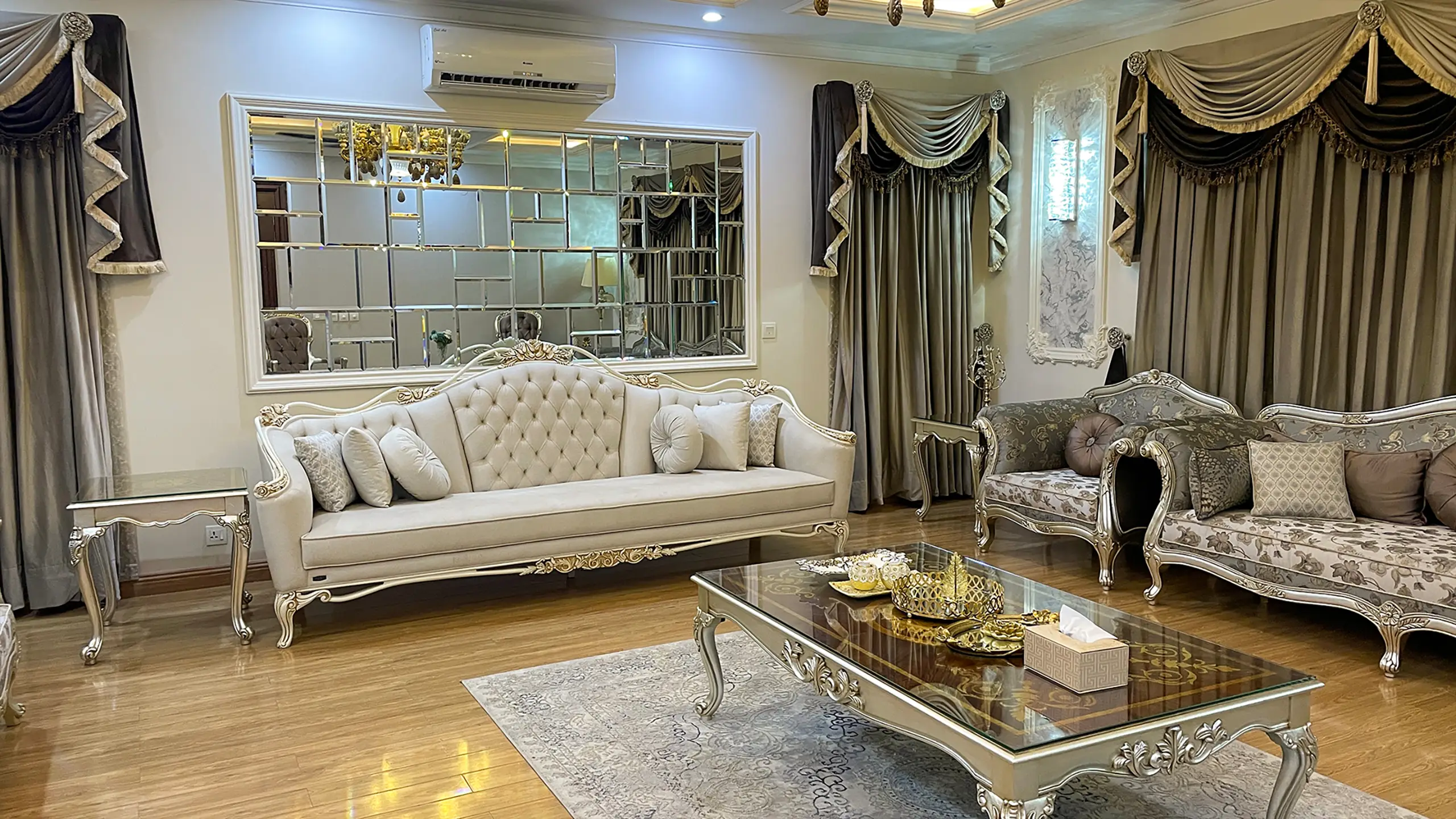 Elegant classic living room with a tufted sofa and decorative mirror, an example of turnkey interior design.